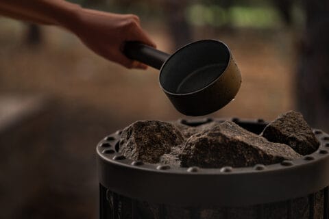 Kuvassa kaadetaan vettä kiukaalle